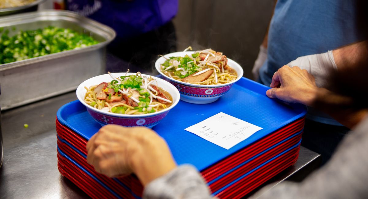 A server brings out an order from the kitchen during the booming 2019 Ramen Fest at Spokane Buddhist Temple.  (Spokesman-Review photo archives)