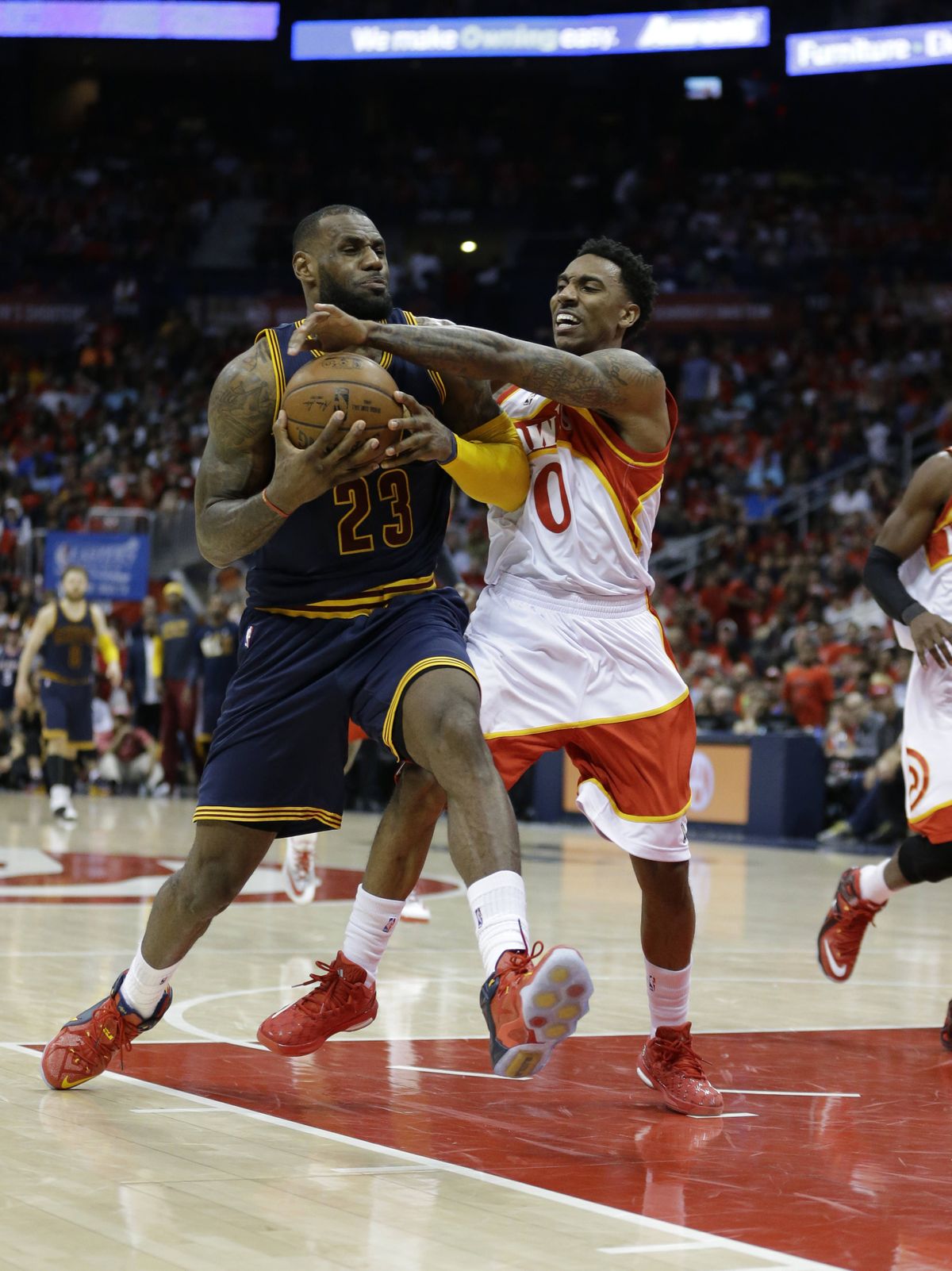 Cavaliers’ LeBron James, who scored 30 points Friday, is fouled by Hawks’ Jeff Teague, right. (Associated Press)