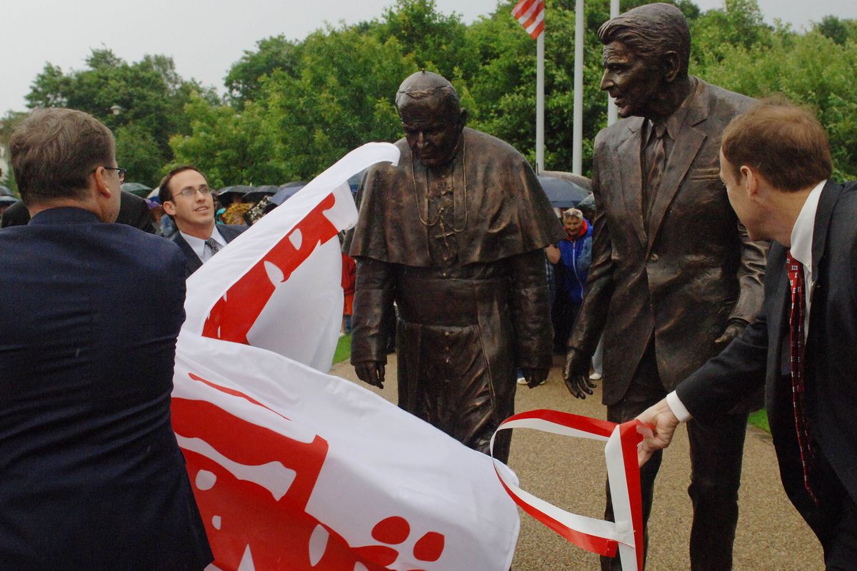 Michael Rosenthal, left, and Bill Cheney unveil the new statue of former President Ronald Reagan and Pope John Paul II in Gdansk, Poland, on Saturday. (Associated Press)