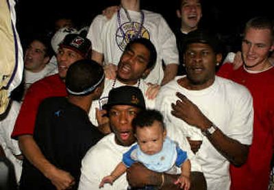 
Nate Robinson, front, holds his five-month-old son, Nahmier, as the Washington Huskies celebrate a No. 1 seed on Sunday in Seattle. 
 (Associated Press / The Spokesman-Review)