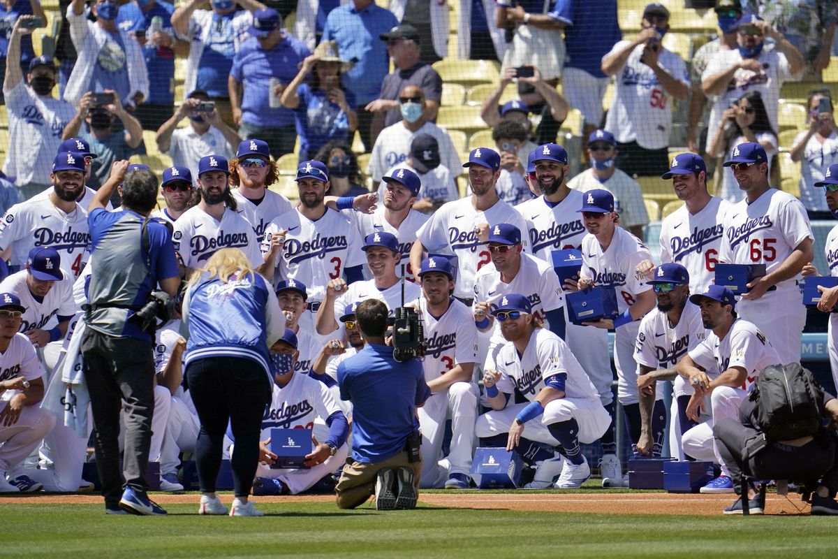 Members of the Los Angeles Dodgers pose for photos with their 2020 World Series Championship rings before a baseball game against the Washington Nationals Friday, April 9, 2021, in Los Angeles.  (Associated Press)