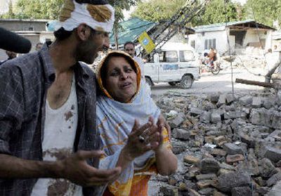 
An injured Kashmiri man comforts his mother on Sunday as she mourns the death of her daughter in a school building collapse in Muzaffar- abad, capital city of Pakistani- administered Kashmir. 
 (Associated Press / The Spokesman-Review)