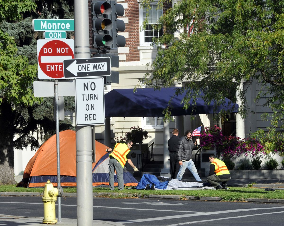 City workers assist protesters in the removal of tents near the Spokane Club on Friday.