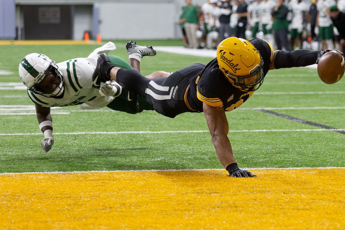Idaho runningback Roshaun Johnson, right, dives past Portland State defensive back Broderick Harrell for a touchdown on Saturday, Oct. 22, 2022, at the Kibbie Dome in Moscow.  (Geoff Crimmins/For The Spokesman-Review)
