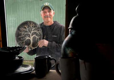 Artist Jeff Harris poses with one of his raku style pottery bowls outside his studio near Medical Lake. 
 (Brian Plonka / The Spokesman-Review)