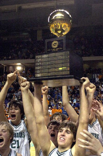 
Northwest Christian senior Karl Richardson hoists the State B championship trophy Saturday. 
 (Christopher Anderson / The Spokesman-Review)