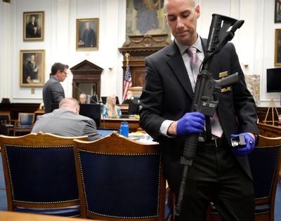 Kenosha Police Department Detective Martin Howard, right, picks up the weapon Kyle Rittenhouse used on Aug. 25, 2020, during Rittenhouse's trial at the Kenosha County Courthouse in Kenosha, Wis., on Nov. 8, 2021. Idaho lawmakers introduced legislation Tuesday that would strengthen Idaho's 