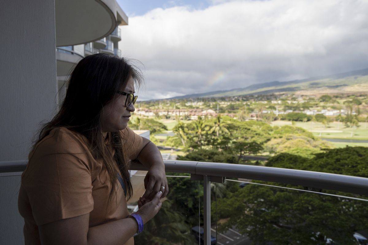 Luz Tumpap looks toward downtown Lahaina, Hawaii, from the balcony of her temporary housing there.    (Mengshin Lin/For The Washington Post)