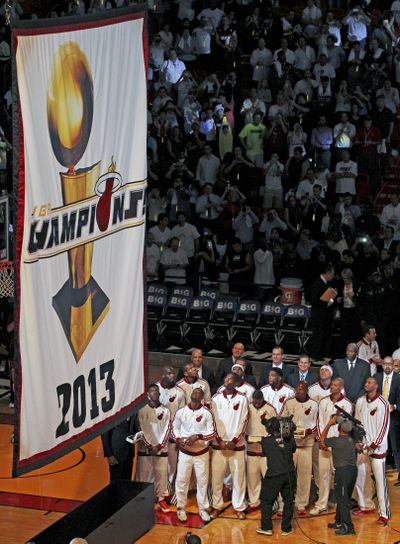 Miami Heat players and coaches watch as the 2013 NBA championship banner is raised Tuesday night. (Associated Press)