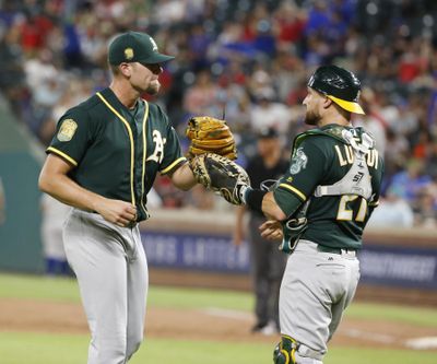 Oakland Athletics catcher Jonathan Lucroy (right) and pitcher Blake Treinen celebrate a win. Lucroy has agreed to a one-year deal with the Los Angeles Angels, according to a source. (Michael Ainsworth / Associated Press)