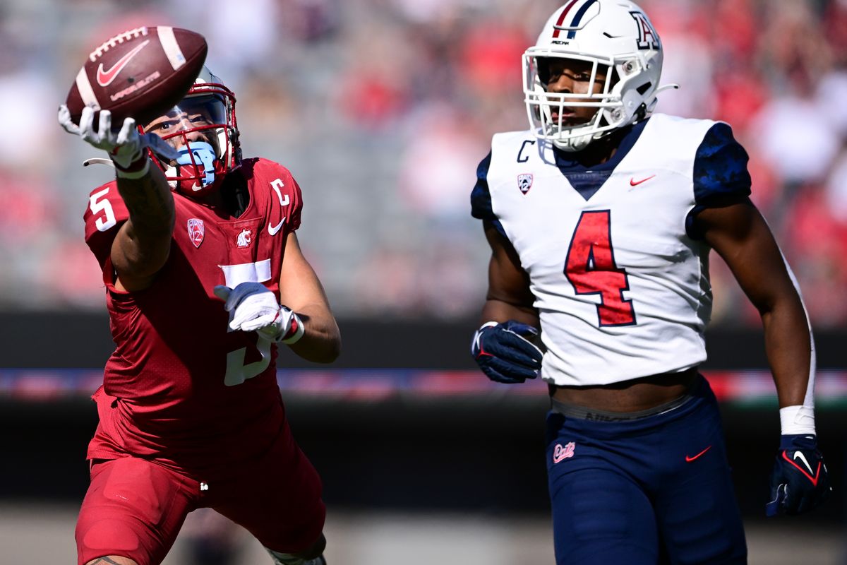 Washington State Cougars wide receiver Lincoln Victor (5) strains for a one handed catch against Arizona Wildcats cornerback Christian Roland-Wallace (4) during the first half of a college football game on Saturday, Nov. 19, 2022, at Arizona Stadium in Tucson, Ariz.  (Tyler Tjomsland/The Spokesman-Review)