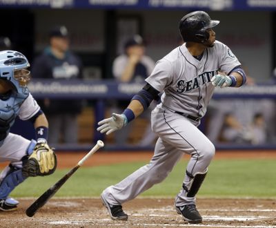 Seattle Mariners' Robinson Cano, right, follows the flight of his two-run single off Tampa Bay Rays starting pitcher David Price during the third inning. (Associated Press)