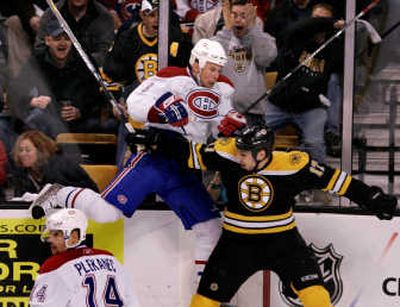 Canadiens defenseman Mike Komisarek, upper left, is slammed into the boards by Bruins left wing Milan Lucic (17). Associated Press
(Associated Press / The Spokesman-Review)