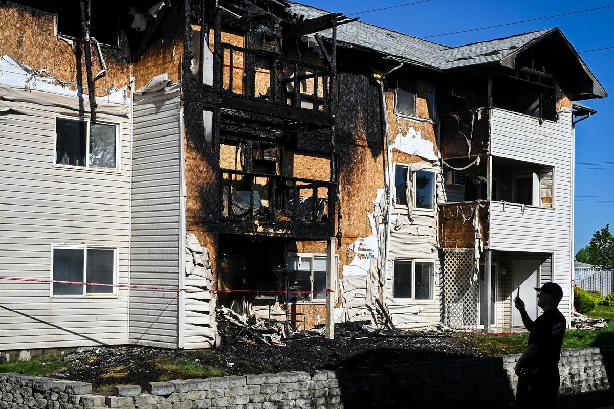 Spokane Valley fire Capt. Dan Ward, from Engine 9, snaps a picture of the fire that destroyed six units in the E building of the Aspen Village Apartments on Monday morning in Spokane Valley. Two people were injured in the unit where the blaze started and multiple pets died.  (DAN PELLE/THE SPOKESMAN-REVIEW)