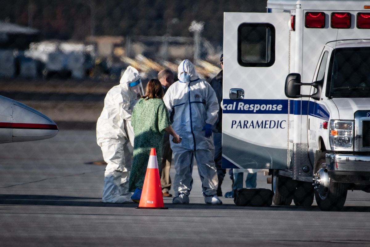 One of two patients infected with the coronavirus  is transferred from a Lear jet to  a waiting American Medical Response ambulance Thursday afternoon at Spokane International Airport. The two coronavirus parents joined two others for treatment at Providence Sacred Heart Medical Center’s Regional Treatment Center/Special Pathogens Unit. (Colin Mulvany / The Spokesman-Review)