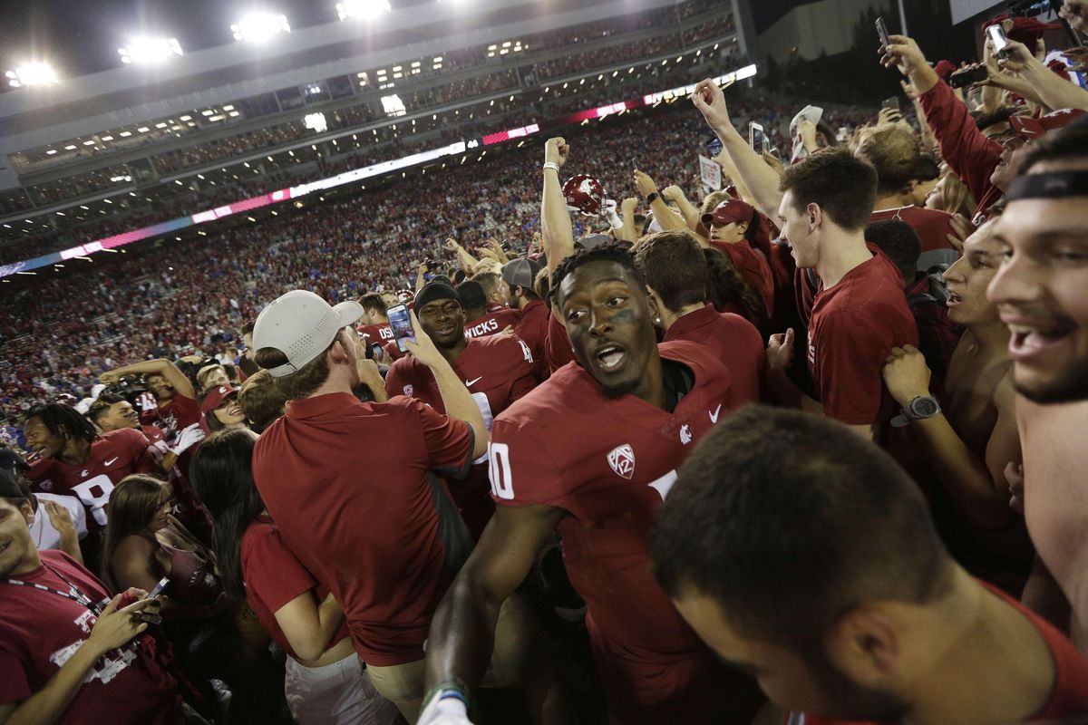 Washington State defensive back Kirkland Parker, center, celebrates with fans after his team