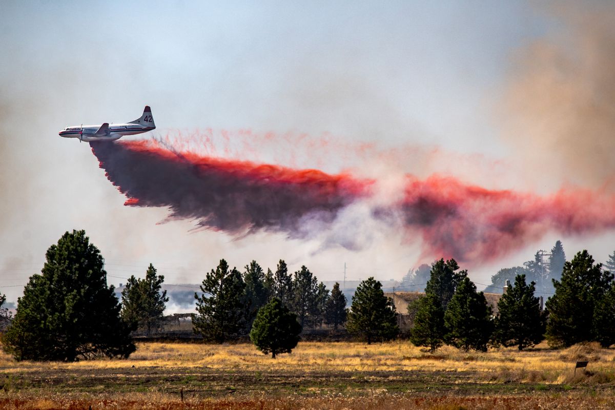 An aircraft makes a fire retardant drop on Fairchild Air Force Base, Thurs., Aug 27, 2020. A brush fire threatened structures in Medical Lake and forced the closure of State Route 902 west of Spokane.  (Colin Mulvany/THE SPOKESMAN-REVIEW)