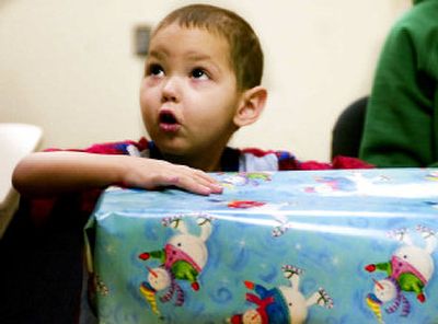 Michael Maupin, 2, picks out a bow for a present he will give to his brother Tuesday afternoon at Sacred Heart Children's Hospital. Patients in the Children's Hospital were able to pick from numerous presents, and high school volunteers helped in wrapping them.
(Kathryn Stevens / The Spokesman-Review)