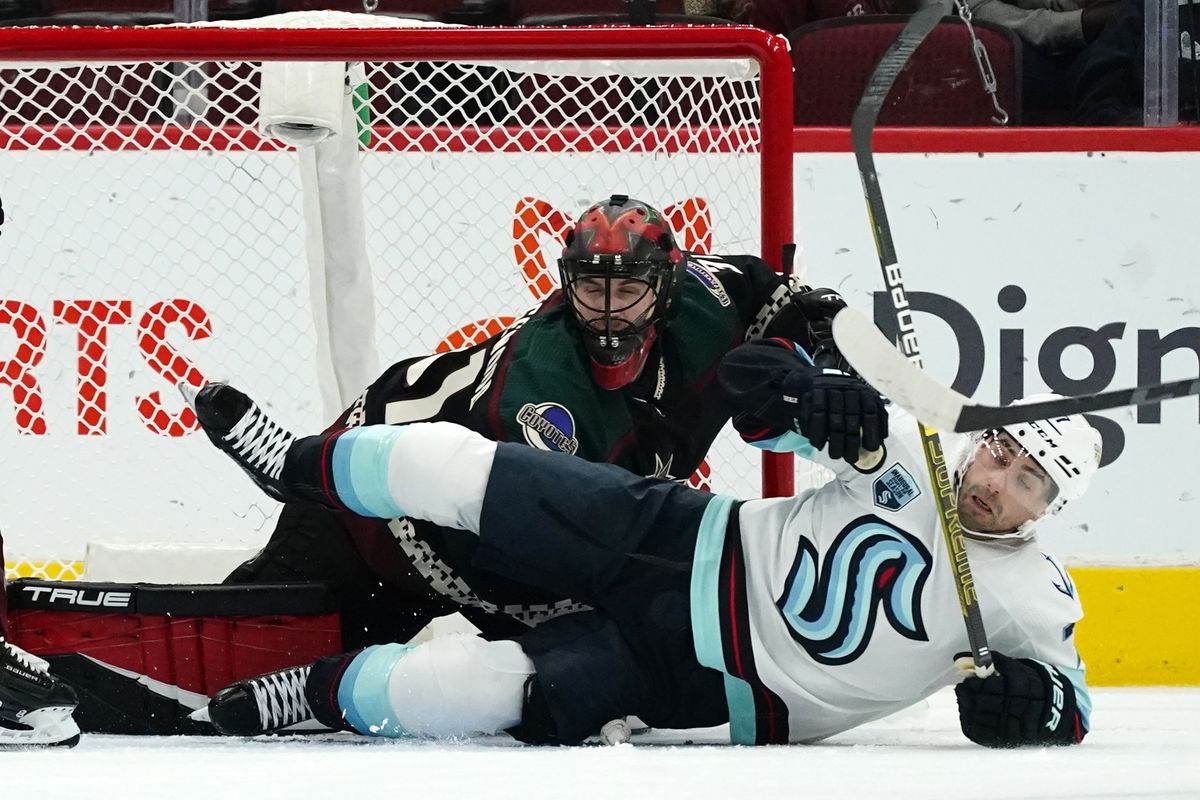 Seattle Kraken right wing Jordan Eberle, right, falls to the ice over Arizona Coyotes goalie Scott Wedgewood, left, during the first period of an NHL hockey game Saturday, Nov. 6, 2021, in Glendale, Ariz.  (Ross D. Franklin)