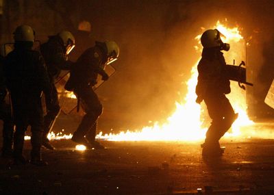 Riot police try to avoid a petrol bomb thrown by protesters during clashes in central Athens late Saturday.  (Associated Press / The Spokesman-Review)