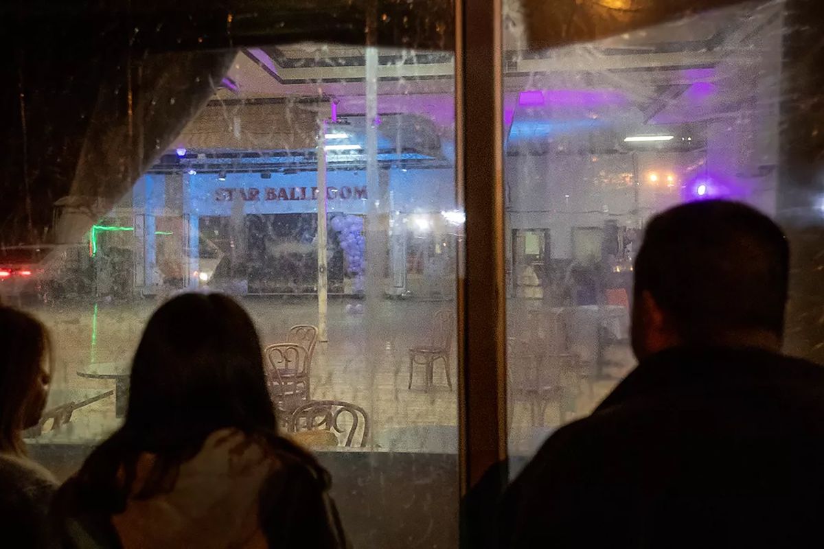 After police tape was taken down, bystanders view the crime scene inside the Star Dance Studio Ballroom.  (Tribune News Service)