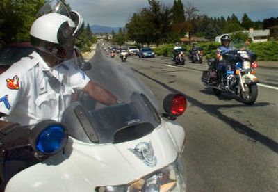 
Spokane police Officer Ken Applewhaite  holds a position on Country Homes Boulevard on Wednesday as motorcycle officers from the State Patrol, county sheriff and city police take part in motorcade escort procedures training. 
 (Christopher Anderson / The Spokesman-Review)