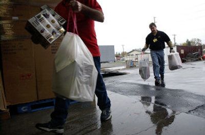 
Liquidation World employee Mike Baughn, right, helps unload recovered stolen items Thursday in Spokane Valley. 
 (Brian Plonka / The Spokesman-Review)