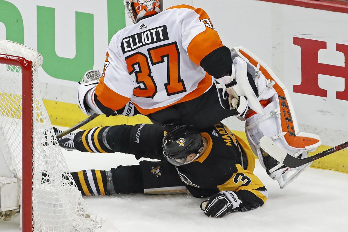 Philadelphia Flyers goaltender Brian Elliott (37) collides with Pittsburgh Penguins’ Olli Maatta (3) during the third period in Game 2 of an NHL first-round hockey playoff series in Pittsburgh, Friday, April 13, 2018. (Gene J. Puskar / Associated Press)
