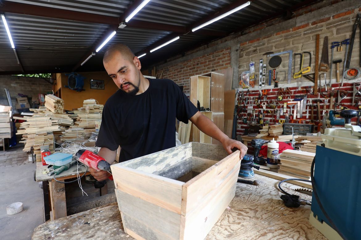 A man works in his family's carpentry workshop