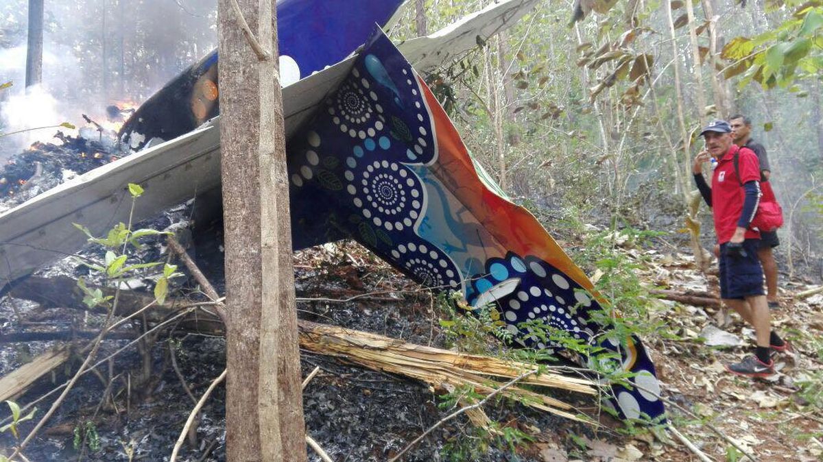 This photo released by Costa Rica's Public Safety Ministry shows people standing at the site of a plane crash near in Punta Islita, Guanacaste, Costa Rica, Sunday, Dec. 31, 2017. (Associated Press)