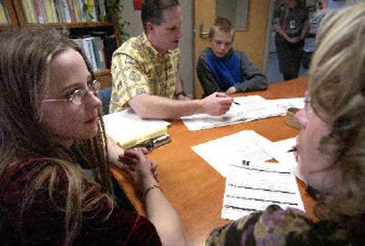 
Left, Centennial Middle School seventh-grader Shayla Smith, 13, listens Thursday as administrative intern Nikki Golden, right, tells her about the Gear Up program, which provides long-term, year-round college preparation for students, beginning in the seventh grade. Seventh-grade teacher Alan Beck, center, goes over the program's information with Andrew Bowerson, 13. 
 (Liz Kishimoto / The Spokesman-Review)
