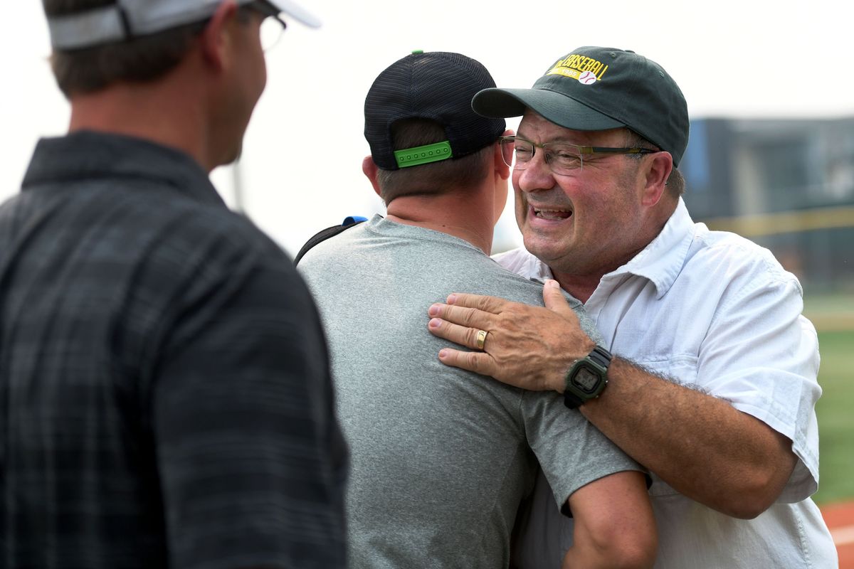 Shadle Park baseball coach Ron Brooks is greeted from players from the 1995 team Aaron Hancock and Tim Amann during his retirement party at Al Jackson Field on Friday, Aug 13, 2021.  (KATHY PLONKA/ THE SPOKESMAN-REVIEW)