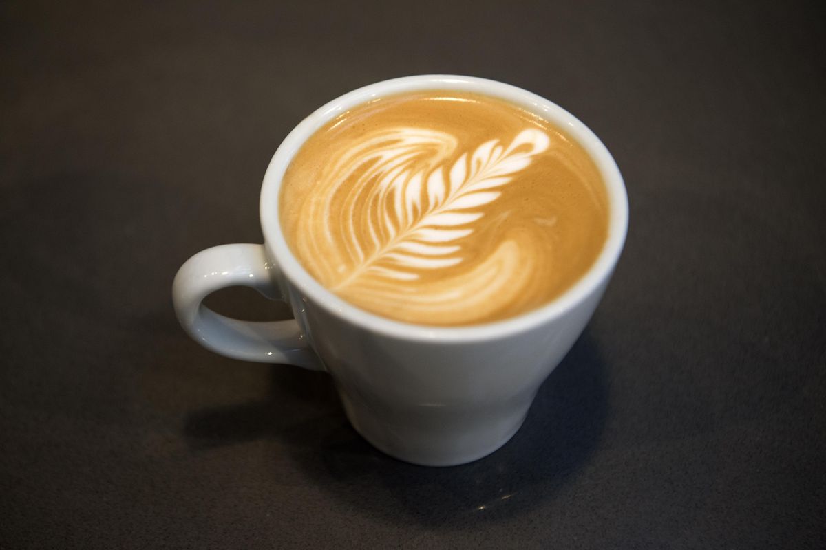 A latte sits on a table top at Revel 77 on Spokane’s South Hill. (Jesse Tinsley / The Spokesman-Review)