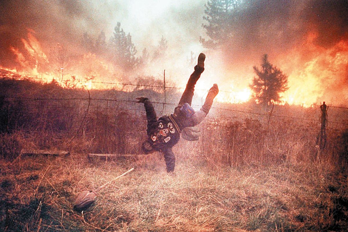 Gordon Maxwell dives over a fence as flames from Firestorm 