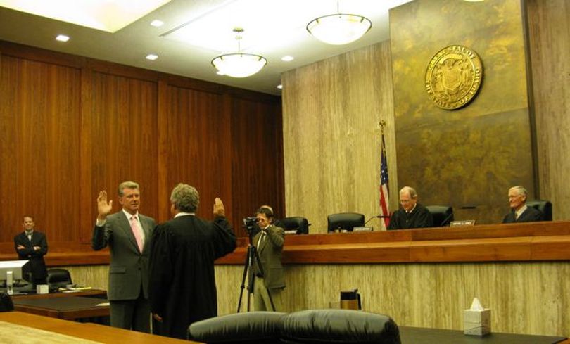 Idaho Gov. Butch Otter administers the oath of office Tuesday to new Idaho Supreme Court Chief Justice Roger Burdick, as the high court's other justices, including outgoing Chief Justice Daniel Eismann, look on. (Betsy Russell)