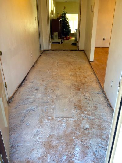 Ceramic tile used to be on top of this ugly concrete mortar. After applying self-leveling floor compound, the homeowner can successfully install laminate floor on top of it. (Tim Carter)