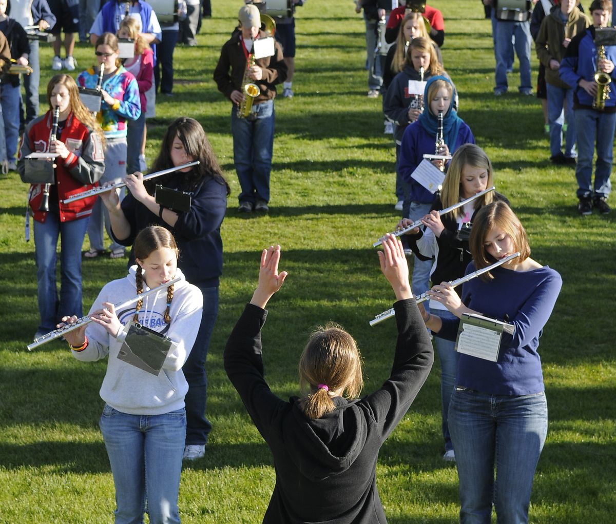 Riverside High School marching band drum major Kim Fry, 18, directs the early-morning practice of the combined bands of Riverside and Deer Park high schools Tuesday, May 11, 2010, at Riverside. Mykaela Hendrix, 15, of Deer Park, front left, and her school mates joined Kim Seitz, 18, of Riverside, front right, for their first practice together on Tuesday. (Dan Pelle / The Spokesman-Review)
