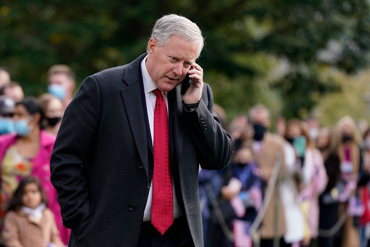 FILE - White House chief of staff Mark Meadows speaks on a phone on the South Lawn of the White House in Washington, on Oct. 30, 2020. At least 13 former Trump administration officials, including Meadows, violated the law by intermingling campaigning with their official government duties. That