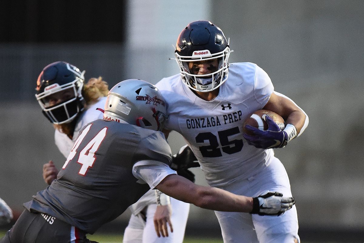 Gonzaga Prep running back Jaden Ortega charges toward Ferris defensive lineman Preston Newcomb during Friday’s Greater Spokane League football game at G-Prep.  (James Snook/For The Spokesman-Review)