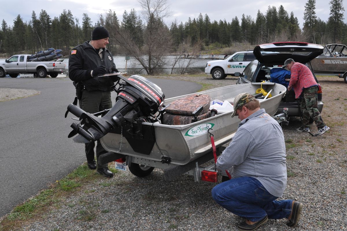 Spokane County Sheriff Deputy Jay Bailey checks the boat of anglers before they launch at West Medical Lake on Saturday. The opening day of the lowland lake fishing season is a good opportunity for the deputies to contact a large number of boaters to be sure their boats are up to snuff. Requirements include: Current registration on board, registration numbers properly shown, boat drivers 35 and under need boater education certificate, life jackets for everyone in the boat and functioning fire extinguisher.  (Rich Landers)