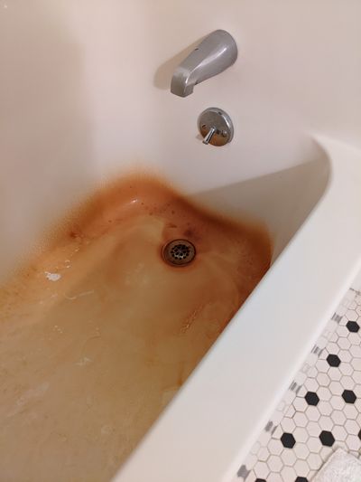 This is deep rust staining on an expensive acrylic bathtub/shower unit. Can the rust be safely removed for less than $1? Yes it can!  (Tribune Content Agency)