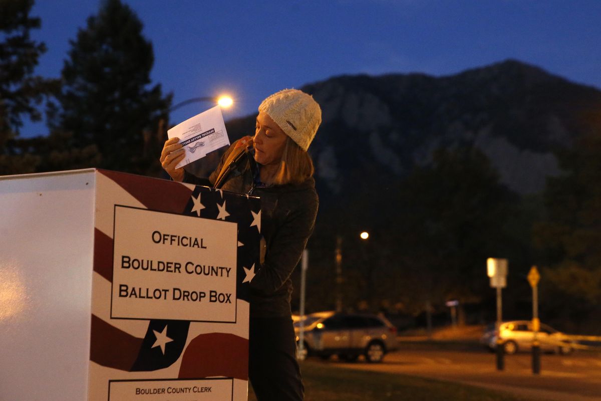 MJ McCoy, who works as a food industry recruiter, puts her completed voter ballot into a drop box at a recreation center before dawn in Boulder, Colo., Tuesday, Nov. 8, 2016. Regarding the significance of having a woman on the ballot, McCoy, who voted for Clinton, says: "It meant a lot to me to see that women finally have a chance to have the highest office in the country. I think it
