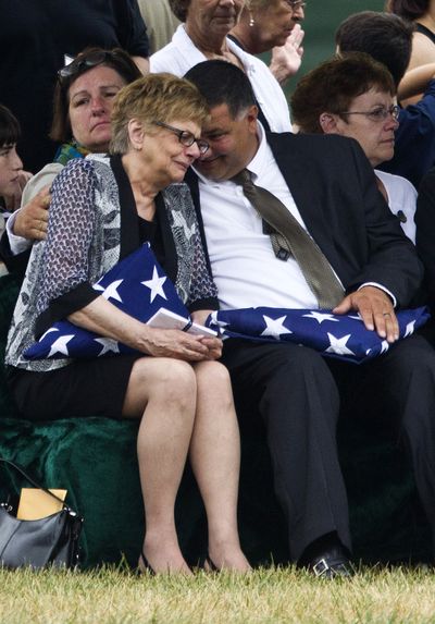 Barbara Annechino is comforted by her brother Jeffrey Christiano during the burial service for their father, Air Force Col. Joseph Christiano, on Monday. (Associated Press)