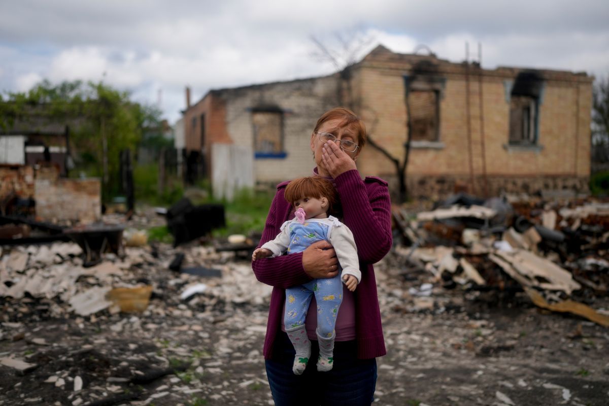 Nila Zelinska holds a doll belonging to her granddaughter, she was able to find in her destroyed house in Potashnya outskirts Kyiv, Ukraine, Tuesday, May 31, 2022. Zelinska just returned to her home town after escaping war to find out she is homeless.  (Natacha Pisarenko)