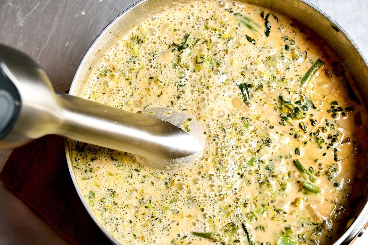 Use an immersion blender to puree the broccolini and parmesan soup.  (Peggy Cormary for The Washington Post/Food styling by Lisa Cherkasky for The Washington Post)
