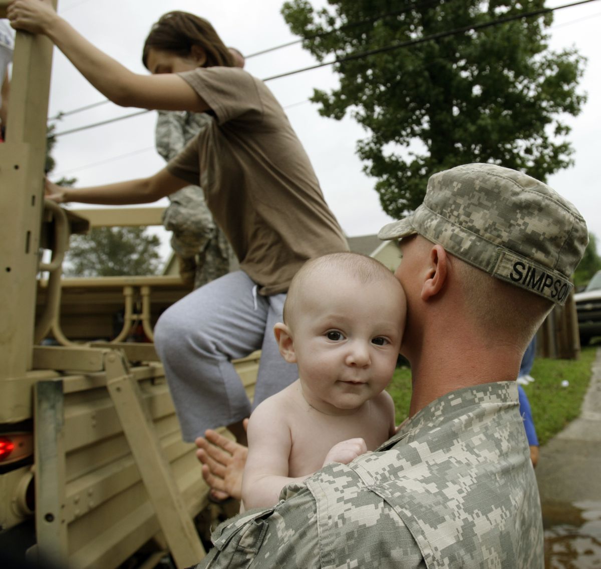 Louisiana National Guard Sgt. Joseph Simpson holds a baby after giving a ride to people through flooded streets to check on their homes after Hurricane Ike in Lake Charles, La., on Saturday. (Alex Brandon / The Spokesman-Review)