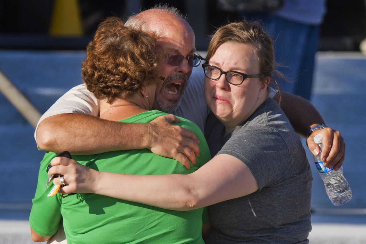 FILE - In this Friday, July 20, 2012 file photo, Tom Sullivan, center, embraces family members outside Gateway High School where he has been searching franticly for his son Alex Sullivan who celebrated his 27th birthday by going to see "The Dark Knight Rises," movie where a gunman opened fire, in Aurora, Colo. (Barry Gutierrez / Fr170088 Ap)