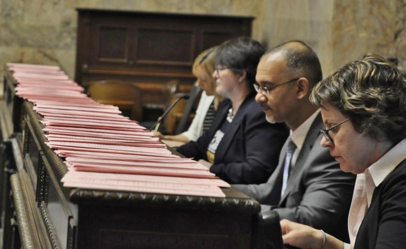 OLYMPIA – Amendments line the bar in front of the Deputy Clerk Nona Snell, Chief Clerk Bernard Dean and other members of the House administration before debate begins on the 2017-19 operating budget. (Jim Camden / The Spokesman-Review)