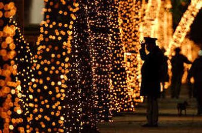 A policeman adjusts his hat near trees decorated with Christmas lights in Mexico City.
(Associated Press / The Spokesman-Review)