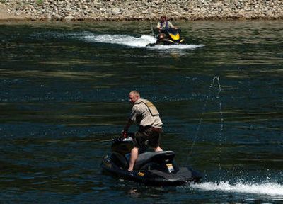 
Kootenai County sheriff's deputies search the water below the rapids at Corbin Park in Post Falls on Friday. 
 (Jesse Tinsley / The Spokesman-Review)